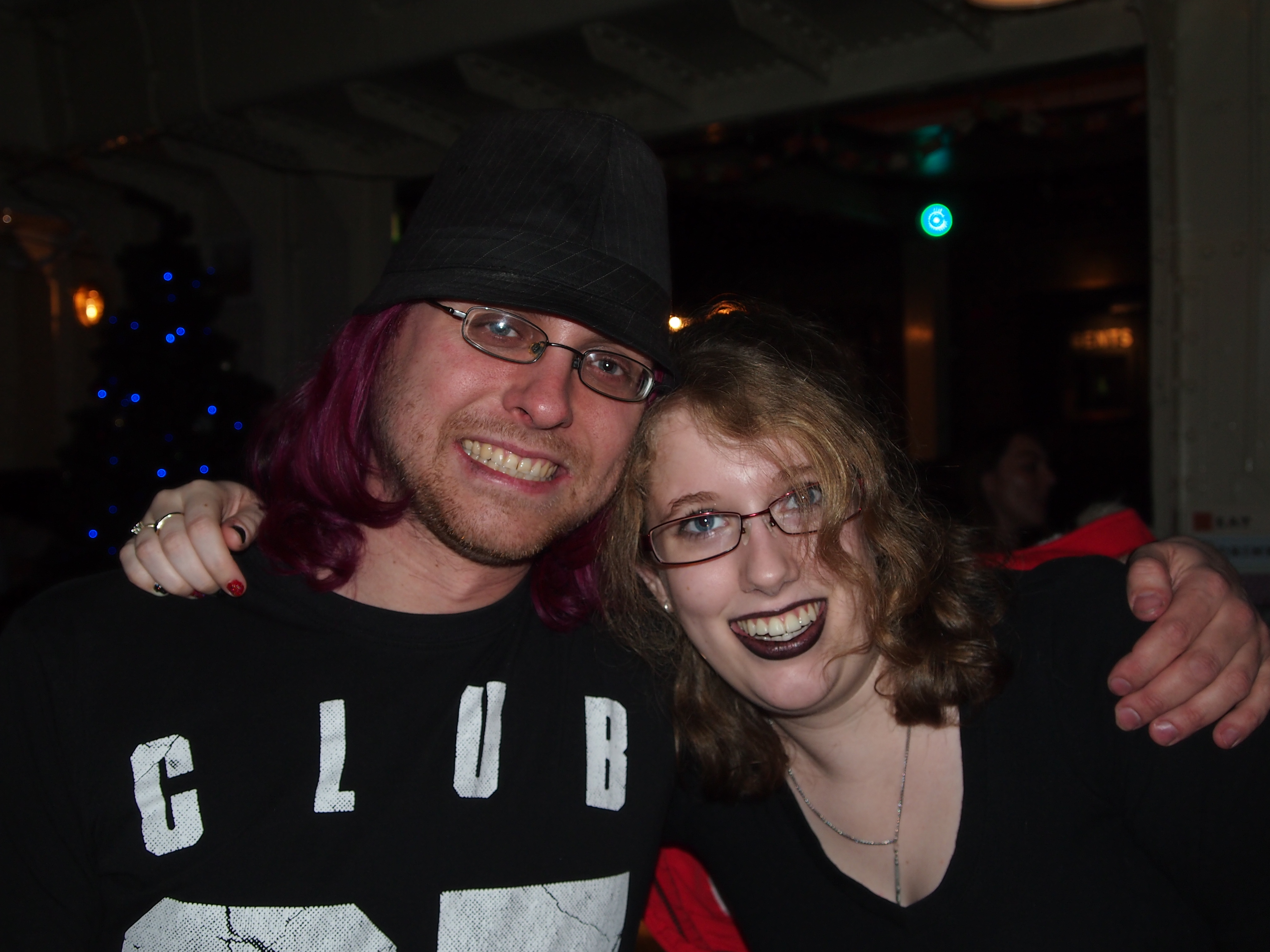 My husband & I when we were students, sat in a local bar at Christmas time. The room is fairly dark but you can see a Christmas tree in the background. We're facing the camera with our arms around each others shoulders.