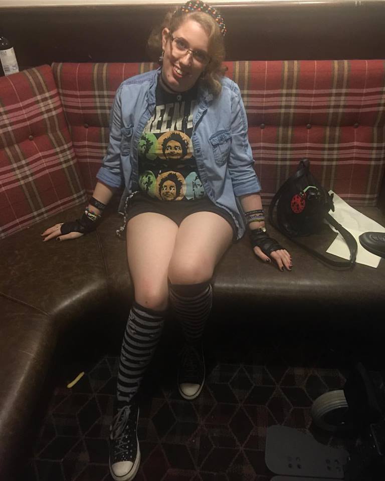 Sat in a local bar as a student. I'm wearing black converse with silver spots on, black & white striped knee socks, black shirts, a Green Day t-shirt, & a denim shirt worn like a cardigan.