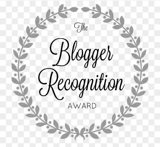 Image description: the Blogger Recognition Award logo. The text is in the centre of a simple wreath, all black & white.