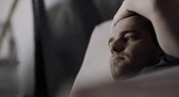 A shot of Jamison lying in bed, looking out of the window, taken from the show.