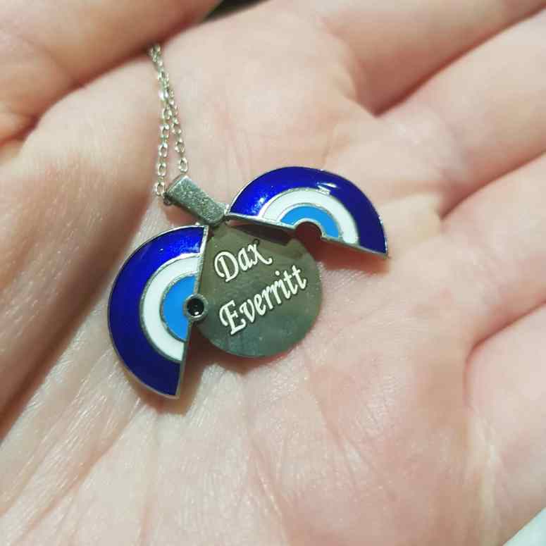 A blue and white necklace that opens up to reveal my new name, Dax.