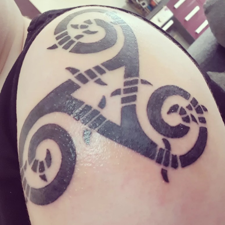 My latest tattoo, this time on my left shoulder. A triskelion, a trio of spirals emanating from a central point, wrapped in barbed wire.